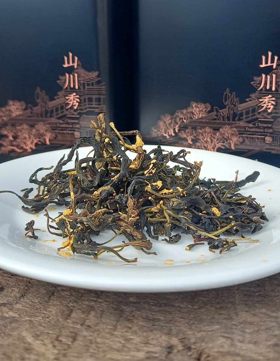 Gold-flecked luxury Goji leaf tea on a plate with a gift box